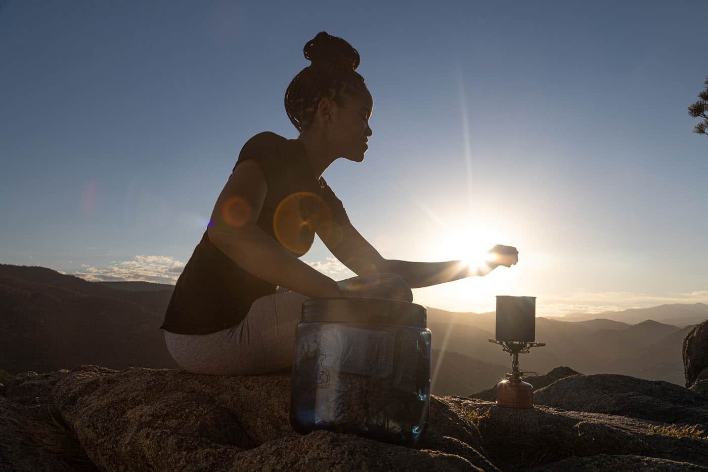 Woman boiling a menstrual cup for hiking on her period in a pot while camping