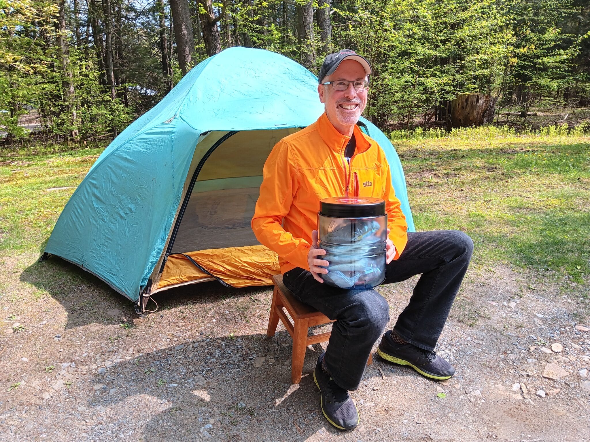 BearVault Adventure Ambassador Barry Auskern with a BV475 in front of a tent.