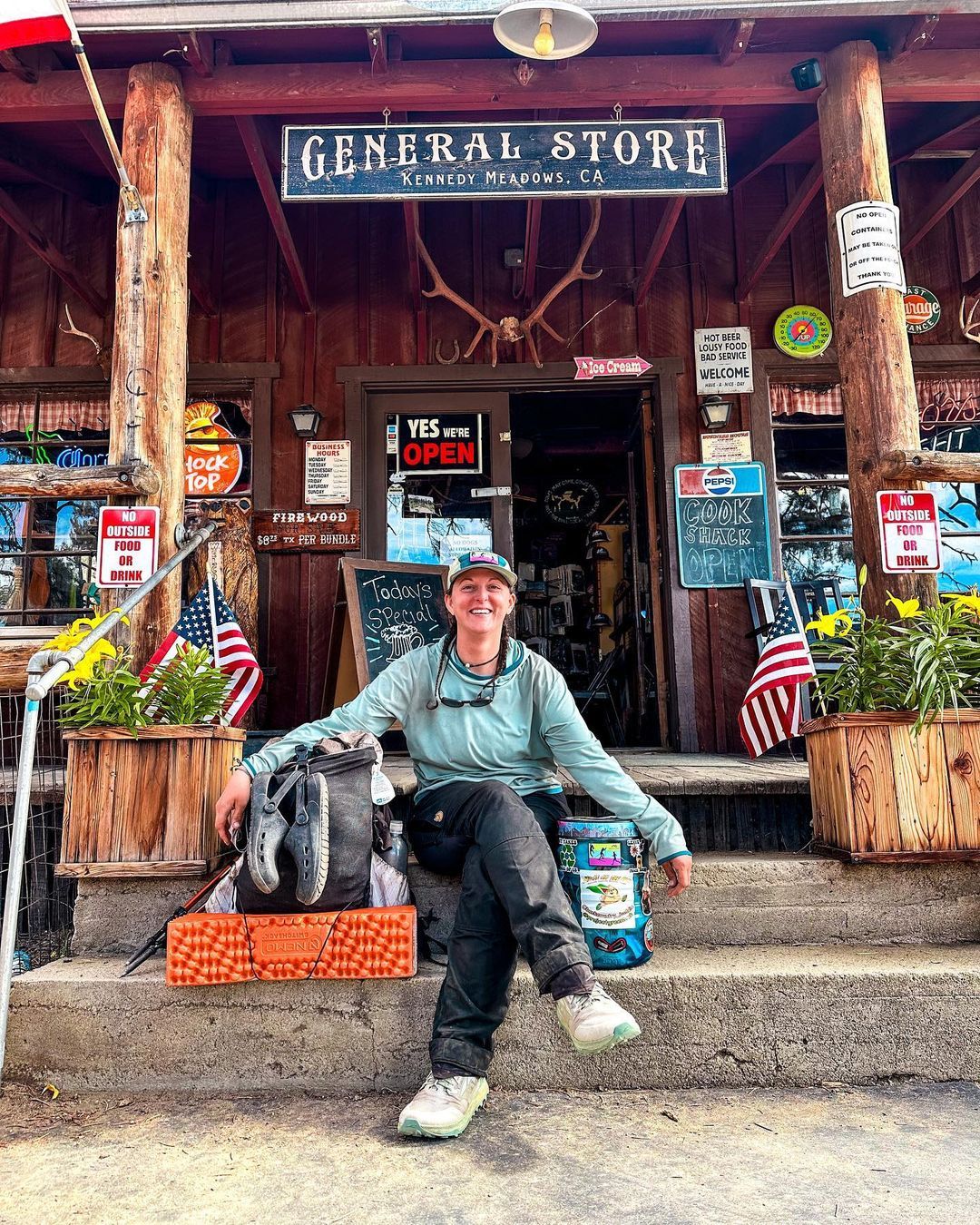 A PCT hiker taking a rest in front of the Kennedy Meadows General Store.