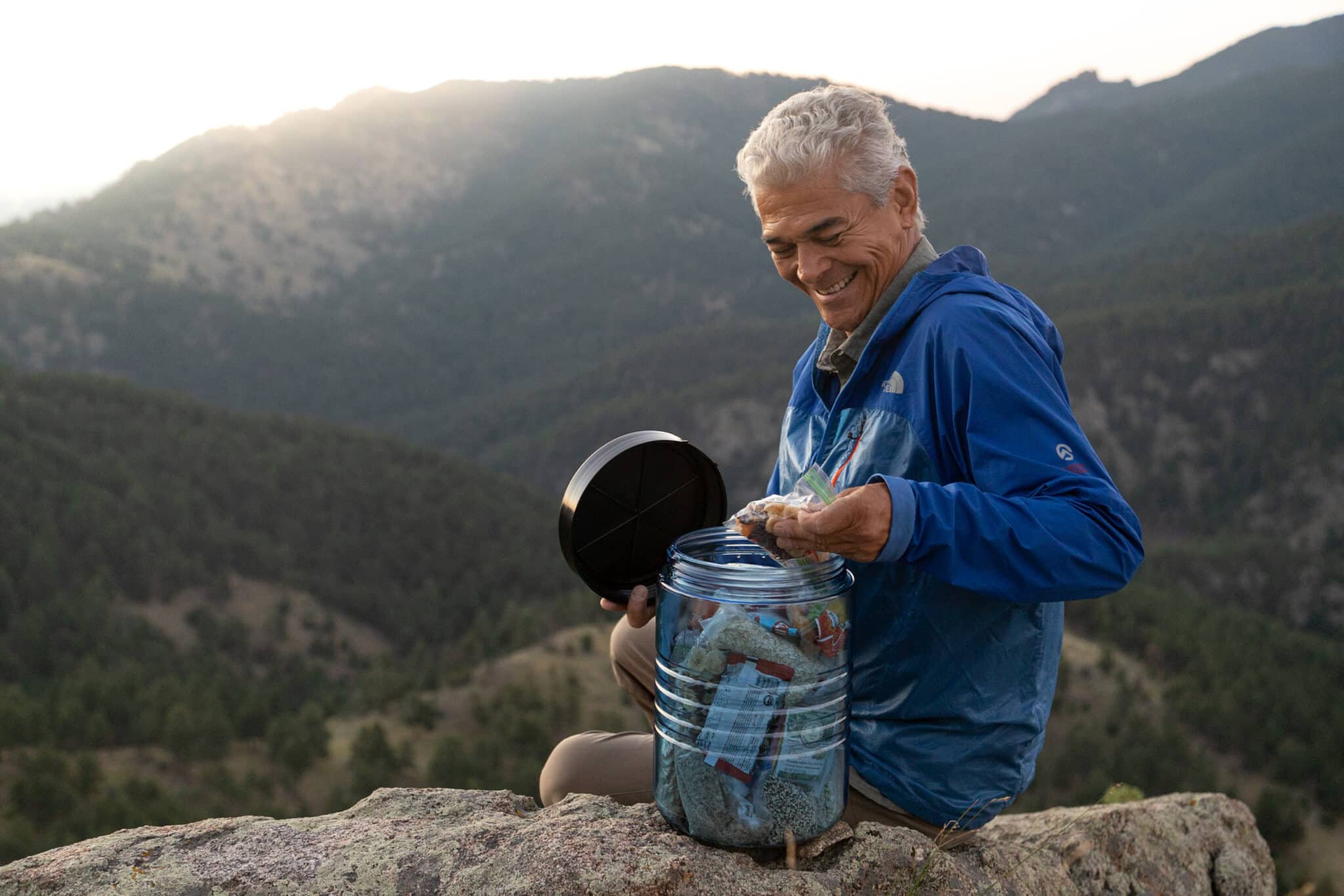 a man gets some food out of his bear canister in the Colorado Mountains